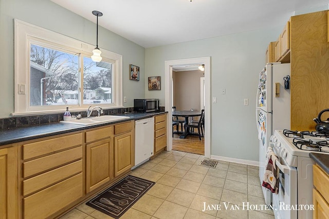 kitchen featuring light tile patterned floors, white appliances, a sink, dark countertops, and pendant lighting