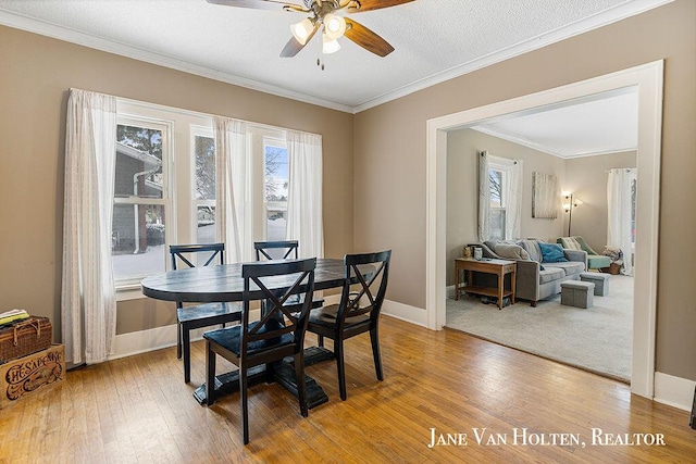 dining area with ornamental molding, ceiling fan, baseboards, and wood finished floors