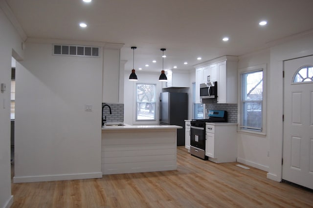 kitchen featuring visible vents, stainless steel appliances, light countertops, white cabinetry, and a sink