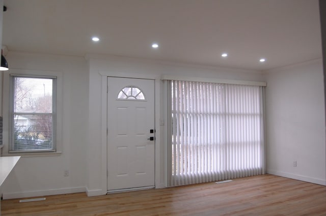 entryway featuring light wood-style floors, recessed lighting, crown molding, and baseboards