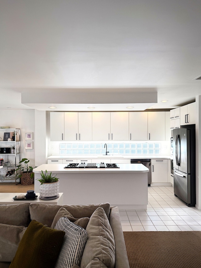 kitchen with open floor plan, light countertops, appliances with stainless steel finishes, and white cabinets