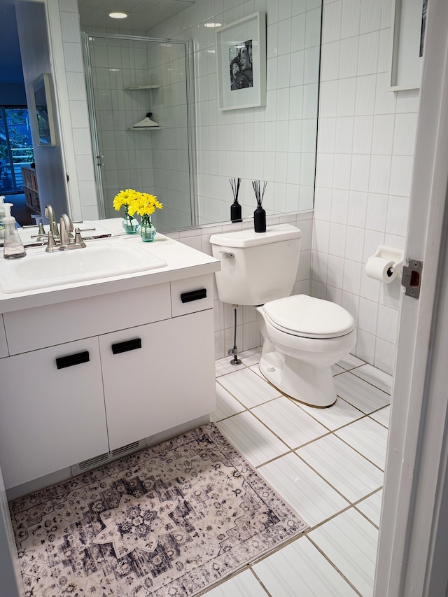 full bathroom featuring toilet, a shower stall, tile walls, and vanity