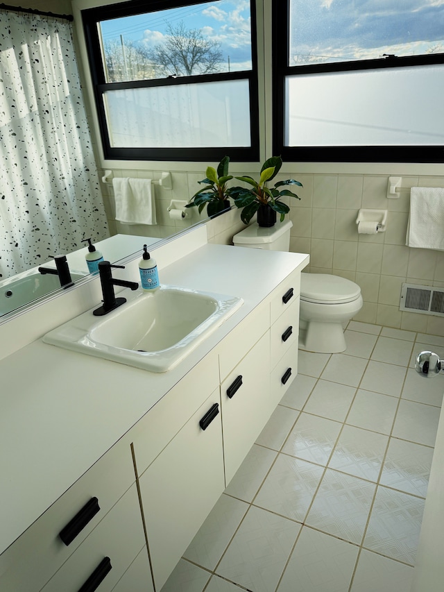 bathroom featuring plenty of natural light, vanity, visible vents, and tile patterned floors