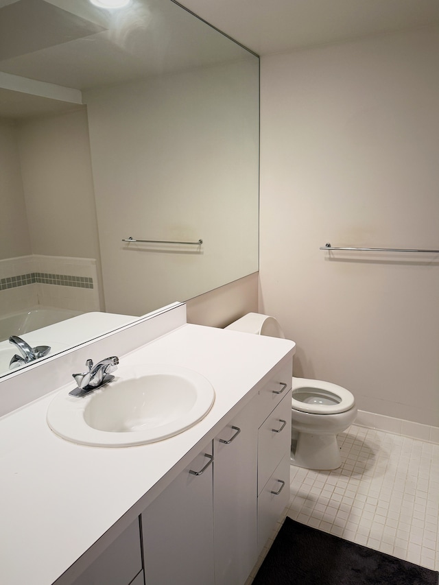 bathroom featuring tile patterned flooring, baseboards, vanity, and toilet