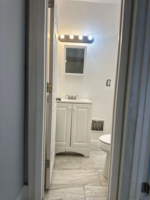 half bathroom with toilet, visible vents, and vanity