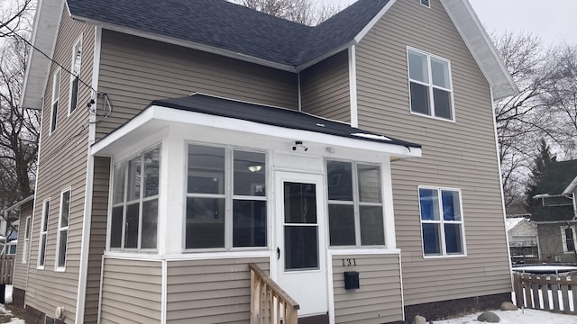 rear view of property with roof with shingles