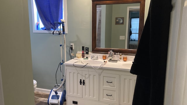 bathroom with a sink, toilet, and double vanity