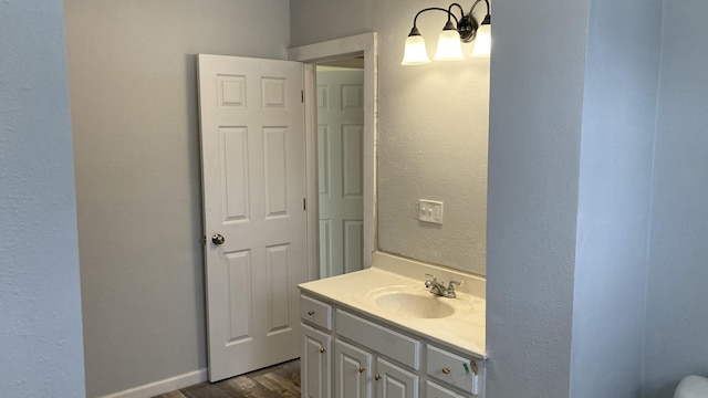 bathroom with a textured wall, wood finished floors, and vanity