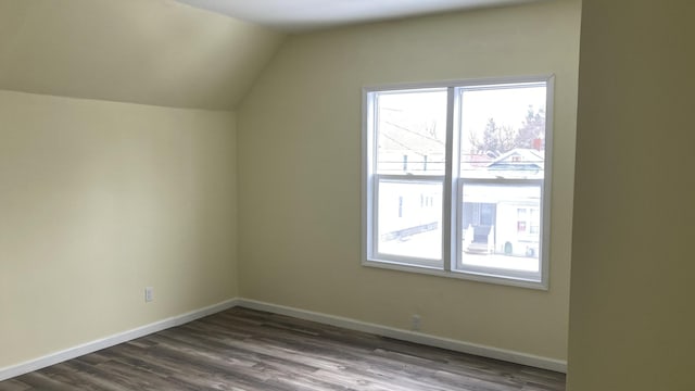 bonus room with vaulted ceiling, wood finished floors, and baseboards