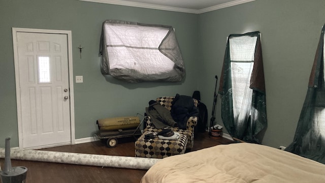 bedroom with baseboards, wood finished floors, and crown molding