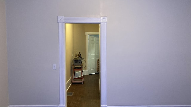 hall with dark wood-type flooring and baseboards