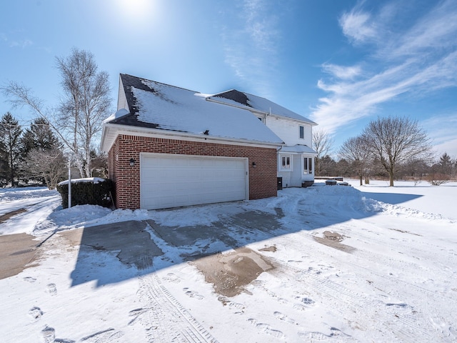 view of snow covered exterior with brick siding