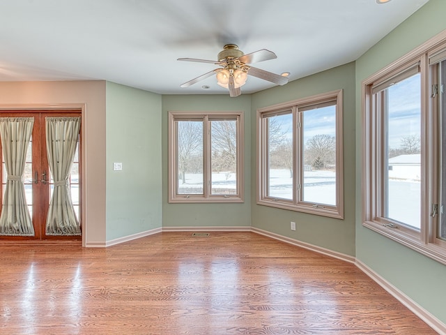 spare room featuring light wood-style flooring, baseboards, and ceiling fan