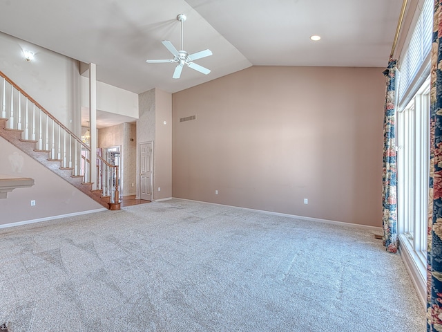 carpeted empty room featuring lofted ceiling, baseboards, stairs, and visible vents