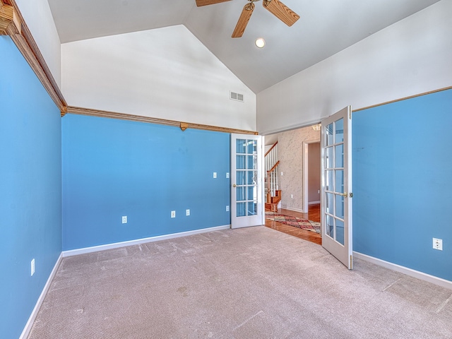 carpeted spare room with high vaulted ceiling, a ceiling fan, visible vents, baseboards, and french doors