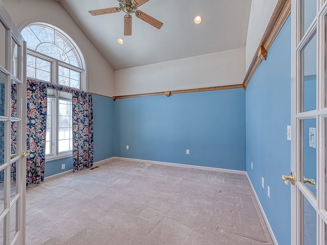 empty room with french doors, a ceiling fan, light carpet, high vaulted ceiling, and baseboards