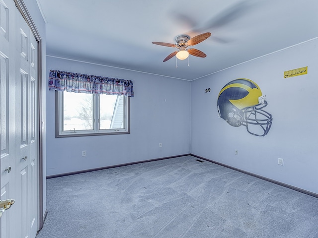 spare room featuring baseboards, a ceiling fan, and light colored carpet