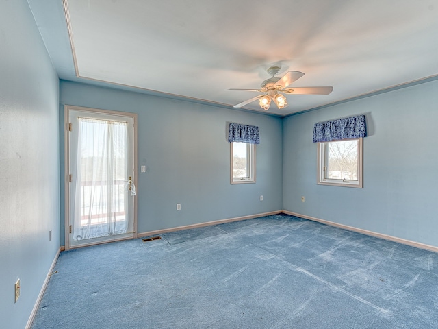 unfurnished room with ceiling fan, carpet floors, visible vents, and baseboards