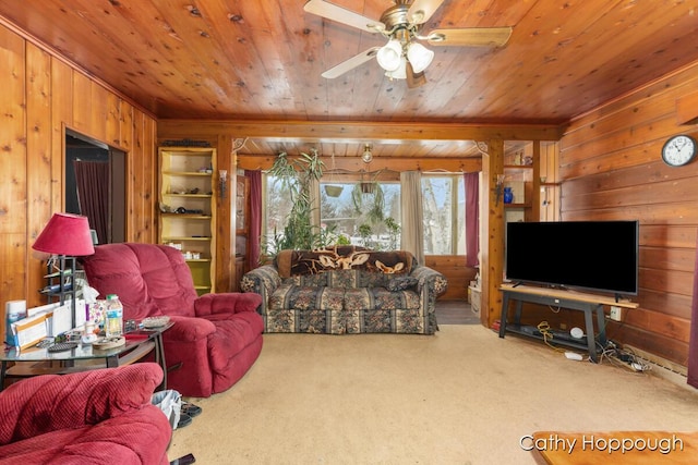 living area featuring ceiling fan, wood walls, carpet flooring, and wood ceiling