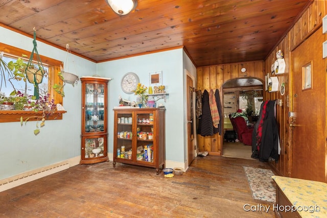 interior space featuring arched walkways, wood finished floors, wood ceiling, and baseboards