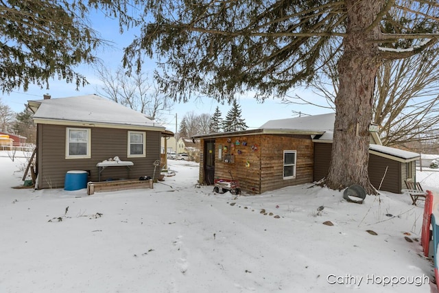 view of snow covered rear of property