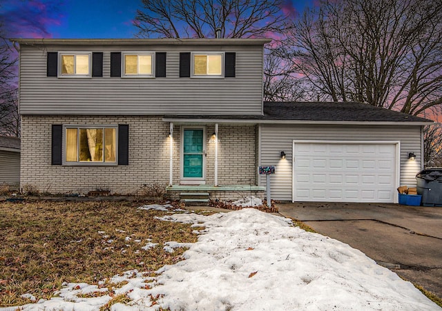 view of front of home with a garage, driveway, and brick siding