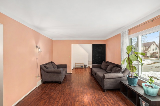 living room with dark wood-style flooring, visible vents, crown molding, and baseboards