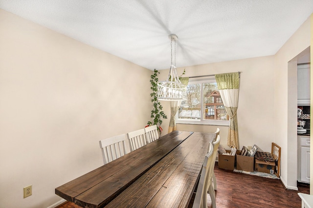 dining area featuring a textured ceiling, baseboards, and wood finished floors