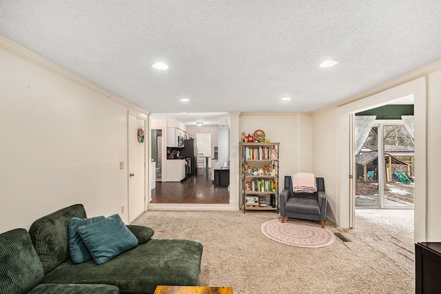 carpeted living area with a textured ceiling, ornamental molding, visible vents, and recessed lighting