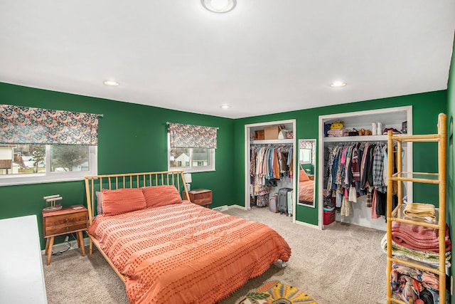 bedroom with recessed lighting, multiple windows, carpet flooring, and two closets