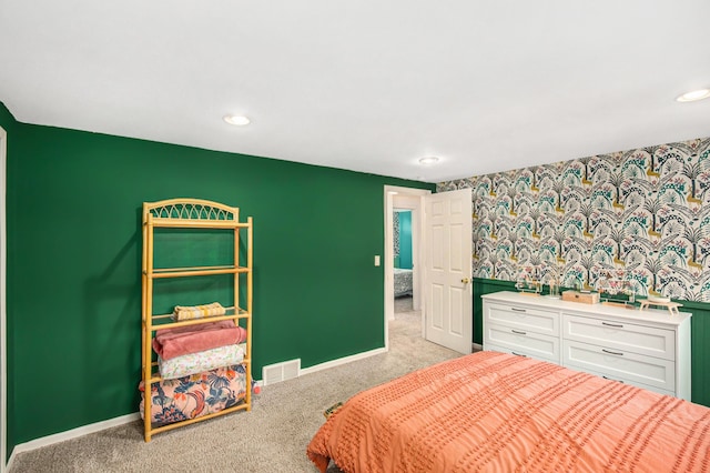 bedroom featuring carpet flooring, visible vents, baseboards, and wallpapered walls