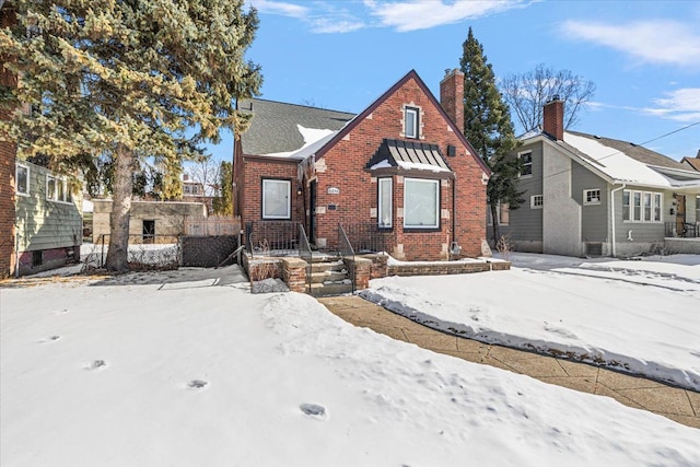 view of front of property with brick siding and fence