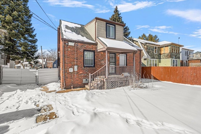 view of front of house with brick siding and fence private yard