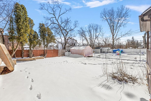 yard covered in snow featuring an outbuilding and a fenced backyard