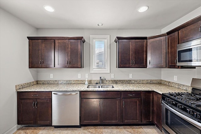 kitchen with appliances with stainless steel finishes, a sink, dark brown cabinetry, and recessed lighting