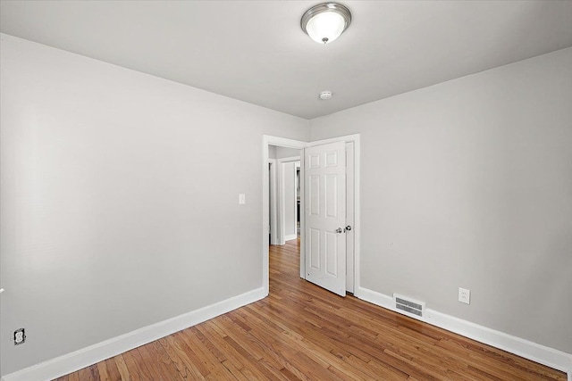 unfurnished room with light wood-style flooring, visible vents, and baseboards