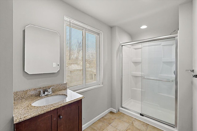 full bathroom featuring a stall shower, vanity, baseboards, and recessed lighting