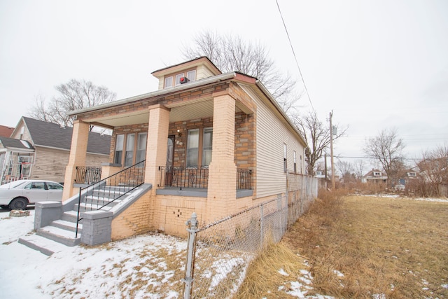 view of front facade with covered porch and brick siding