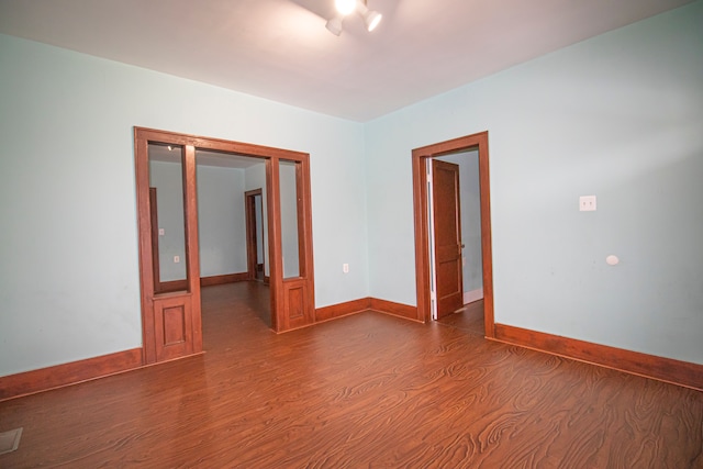 unfurnished room with baseboards and wood finished floors