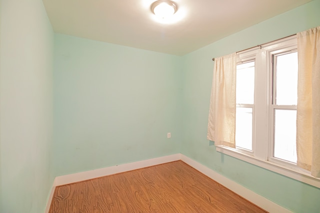 empty room featuring baseboards and wood finished floors