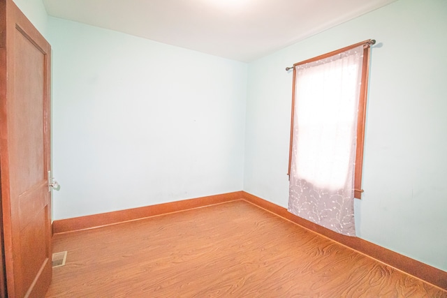 unfurnished room with visible vents, baseboards, and wood finished floors