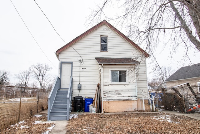 back of house featuring entry steps and fence