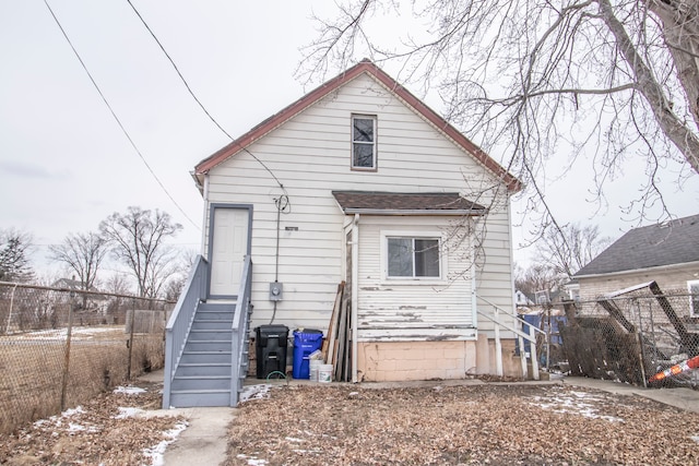 rear view of house with entry steps and fence