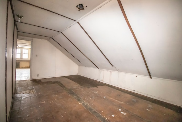 additional living space featuring vaulted ceiling and radiator heating unit