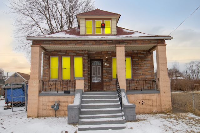 bungalow-style house featuring covered porch and brick siding