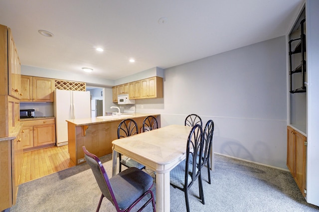 dining room featuring light carpet, baseboards, and recessed lighting