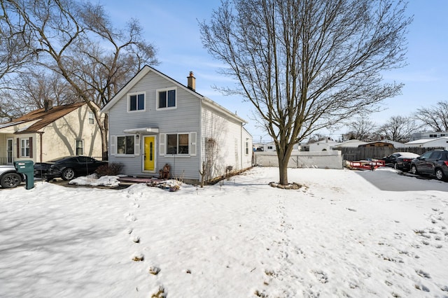 view of front of home with a chimney and fence