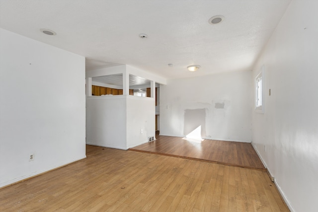 empty room with light wood-type flooring and visible vents