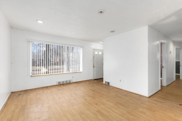 empty room featuring visible vents and light wood finished floors