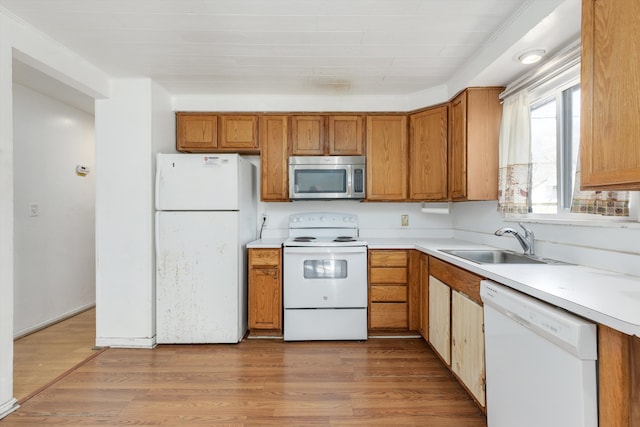 kitchen featuring light countertops, white appliances, and brown cabinetry